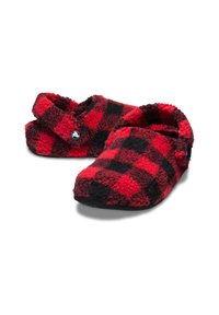 Chaussons en polaire à carreaux rouges et noirs avec une texture douce, un design ouvert à l'arrière et un accent de logo circulaire sur le côté.