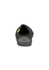 Black slip-on shoe with a textured fabric upper, open back, rubber sole, and a small yellow accent on the side. Soft interior lining.