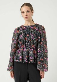 Langermet bluse i gjennomsiktig svart stoff med livlig blomstertrykk i rosa og rødt, med rynket halslinning og peplumkant.
