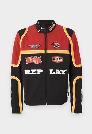 Red, black, and yellow racing jacket with zipper, patches including "Replay Helmet," "Old Glory," and bold "Replay" text on front.