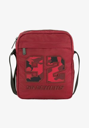 Bolso de hombro de tela roja con cierre de cremallera, que presenta un gran estampado de camuflaje con el "92" y el logotipo de "SKECHERS". Incluye una correa ajustable negra.