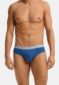 Blauwe katoenonderbroeken met een grijze elastische tailleband waarop het "HANRO" logo staat. De gladde textuur en de aansluitende pasvorm vergroten het comfort en de steun.