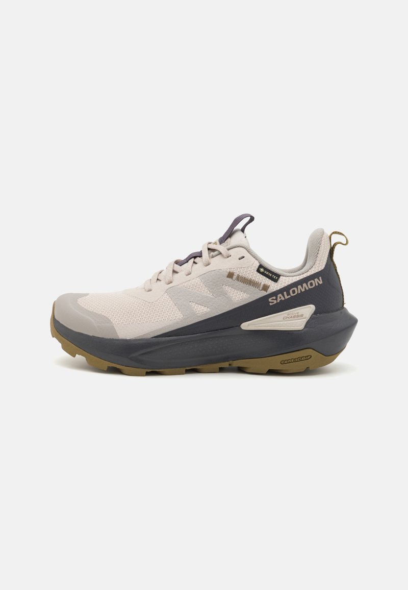 Chaussure de sport Salomon beige et gris foncé avec semelle épaisse, label GORE-TEX et détails de marque sur fond blanc.