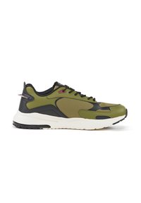 Atletische sneaker in olijfgroen en zwart, met een textuur bovenop, vetersluiting en een witte tussenzool met een zwarte rubberen loopzool.