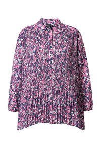 Camisa floral con cuello abotonado, mangas largas, diseño plisado y fondo azul marino con patrones de flores rosas y blancas.