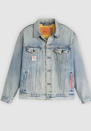 Lyseblå denimjakke med frontknaplukning, brystlommer og en rød accentlabel. Har en kontrasterende gul ternet foring.