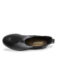 Zapato negro de piel tipo slip-on con punta redonda, textura suave y paneles laterales elásticos para ponerse y quitarse fácilmente. Cuenta con una lengüeta de talón texturizada para mayor agarre.