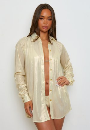 Gouden metallic overhemd met lange mouwen en een kraag, met een relaxte pasvorm en een verticale glinstering.