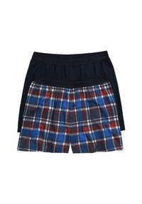 Dvě sady boxerky: jedny jednobarevné námornicky modré s měkkým elastickým pasem, druhé kostkované modré, červené a bílé s knoflíkem, položené na sobě.