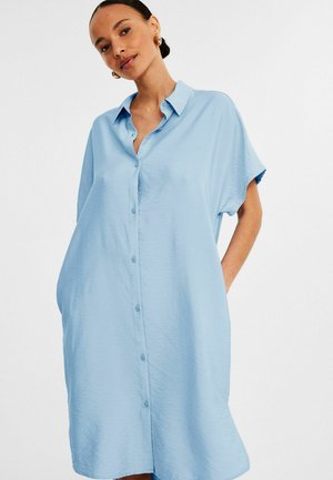 Light blue shirt dress made of smooth fabric, featuring a button-up front, short sleeves, and side pockets, with a relaxed, loose fit.