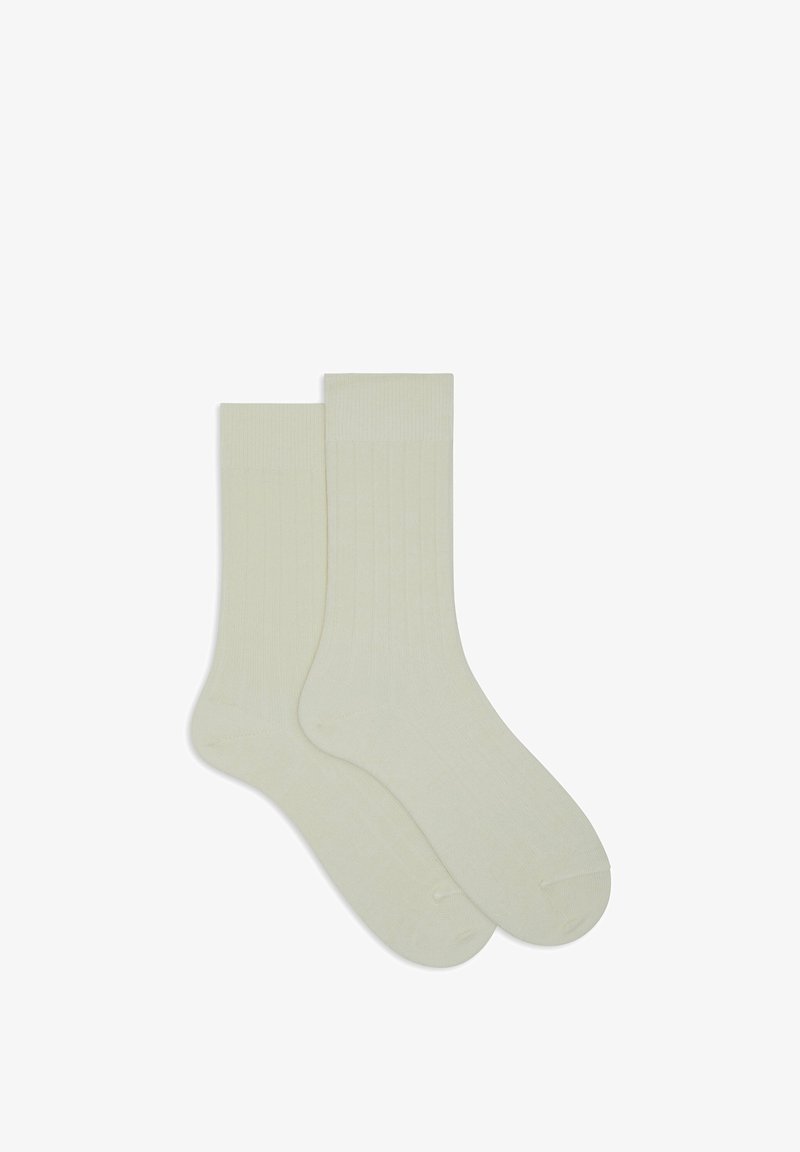 Cream-colored cotton socks with a ribbed texture, featuring a mid-calf length and reinforced toe and heel for durability.