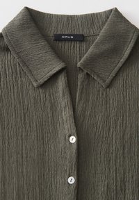 Textured olive green shirt with a collared neck, featuring a button-down front and three white buttons, from the brand OPUS.