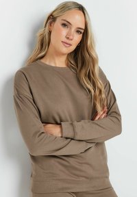 Felpa marrone realizzata in tessuto morbido, con scollo rotondo e maniche lunghe con polsini a coste. Design semplice senza motivi o dettagli.