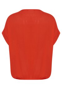 Blouse rouge à coupe ample, col rond et manches dolman courtes. Le tissu est lisse et léger, avec un ourlet arrondi en bas.