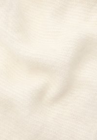 Vitt texturerat stickat tyg med en mjuk, lätt fuzzy yta, som har ett subtilt mönster av diagonala linjer. Lätt och följsam.