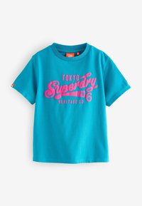 Turkis bomulds t-shirt med korte ærmer, der har stort pink grafisk tekst "TOKYO Superdry JPN" og "HERITAGE CO." på fronten.