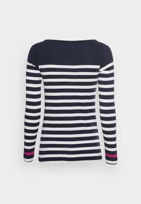 Marinblå och vit randig långärmad skjorta med en vid halsringning. Har en enfärgad marinblå överdel och en rosa detalj på ena ärmen.