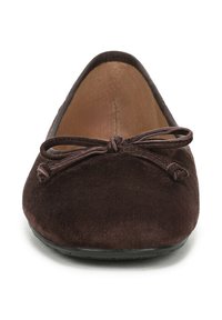 Ballerine in suede marrone con punta arrotondata e un fiocco decorativo nella parte anteriore. La suola è piatta e ha un design semplice.