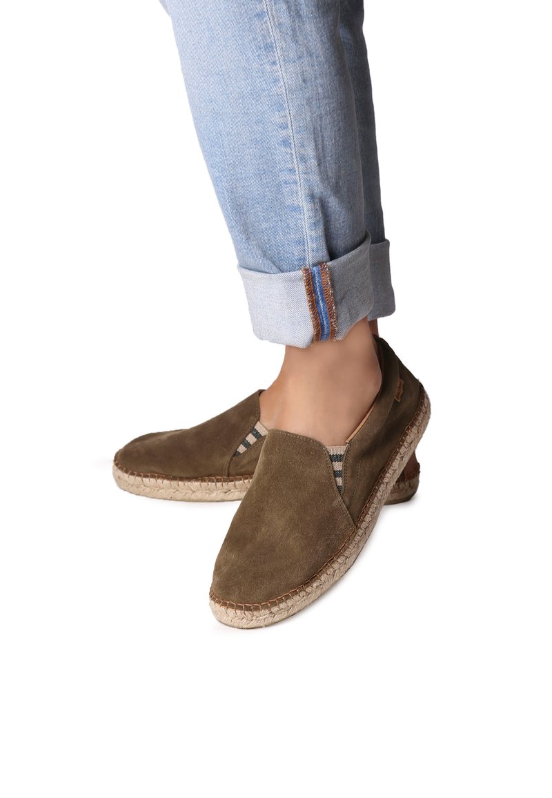 Bruna mocka espadrillos med elastiska sidoinlägg och vävda jutesulor. Bärs med uppvikta ljusblå jeans som avslöjar sömdetaljer vid fållarna.