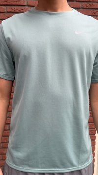 Gaiši zaļa Nike īsroku T-krekls no strukturēta materiāla. Augšējā kreisajā pusē atrodas rozā Nike logo. Apaļa apkakle, vaļīgs piegriezums.