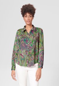 Langarm overhemd met een groen, paars en roze paisleypatroon; heeft een klassieke kraag en een afgeronde zoom.