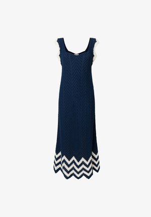 Tamno plava haljina s teksturiranim riblja kost uzorkom, sa bijelim valovitim rubovima na donjem dijelu i čipkastim detaljima na ramenima.