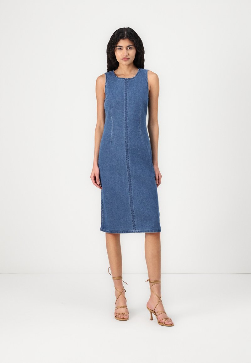 Džinsinis midi suknelė, be rankovių ir su apvaliu iškirpimu. Turi centrinius siūlus ir tiesų pjūvį, vidutinio mėlynumo plovimas. Be raštų ar dekoracijų.