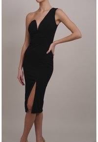 Svart, figurnära klänning med en axel-design, djup V-ringning och hög slit upp till låret. Tillverkad av mjukt, stretchigt tyg.