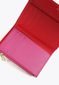 Interior de cartera de cuero rojo y rosa con múltiples ranuras para tarjetas y un cierre con cremallera, con textura suave y colores en contraste.