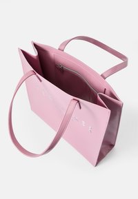 Saco tote sintético rosa com acabamento brilhante, apresentando alças superiores, um bolso interior com fecho e logotipo da marca em relevo na parte frontal.