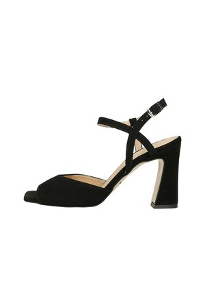 Sandalo aperto in suede nero con una fascia larga nella parte anteriore, design incrociato alla caviglia e tacco quadrato con finitura a contrasto.