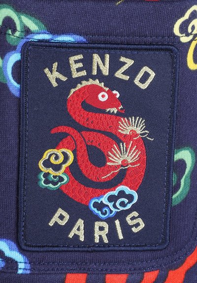 Textiel patch met een ontwerp van een rode draak, gouden letters "KENZO PARIS" op een donker marineblauwe achtergrond. Bevat geborduurde kleurrijke wolkenpatronen.