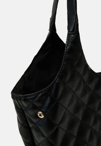 Czarna pikowana torebka wykonana ze sztucznej skóry. Posiada miękkie wnętrze oraz złote detale metalowe. Zaokrąglony, usztywniony kształt.