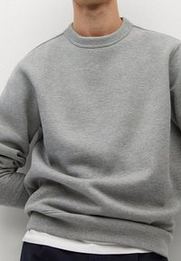 Szary sweter z okrągłym dekoltem wykonany z miękkiego materiału, z długimi ściągaczami na dekolcie i mankietach, o luźnym kroju i minimalistycznym designie.