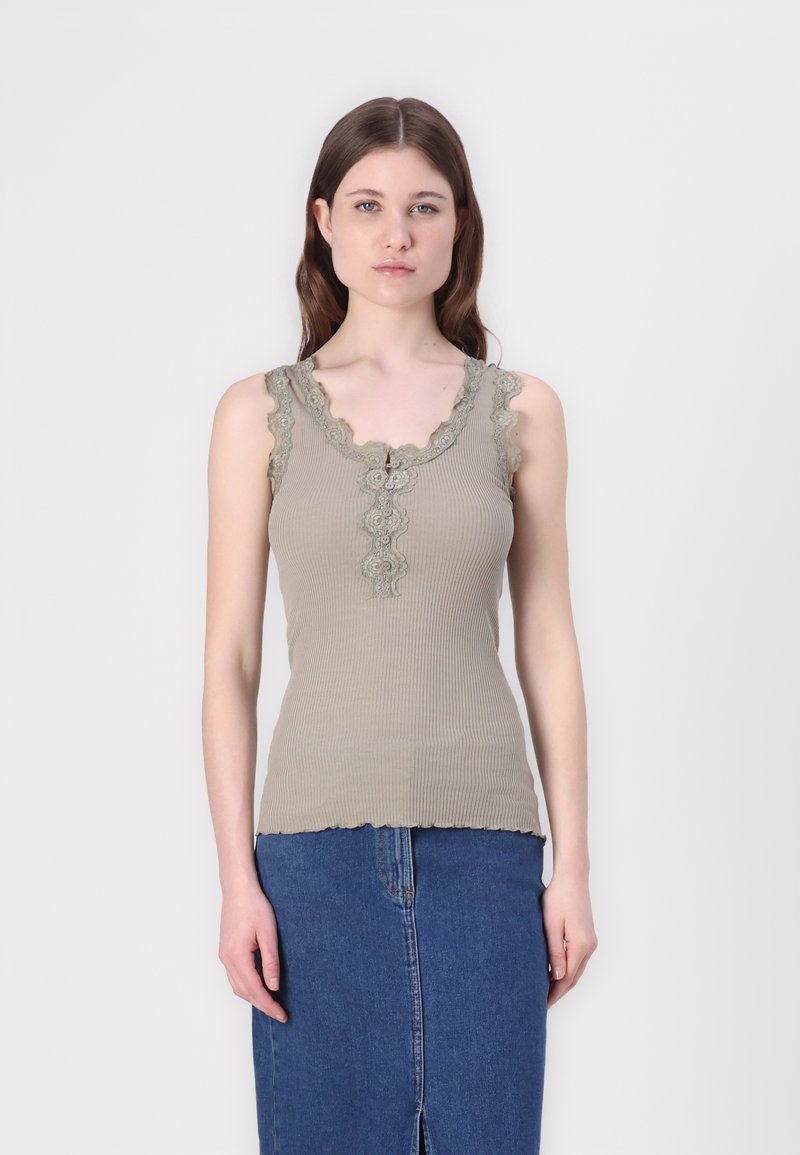 Khaki geribbelde tanktop met een scalloped kantafwerking bij de halslijn, met een klein knoopdetail, gecombineerd met een denimrok.
