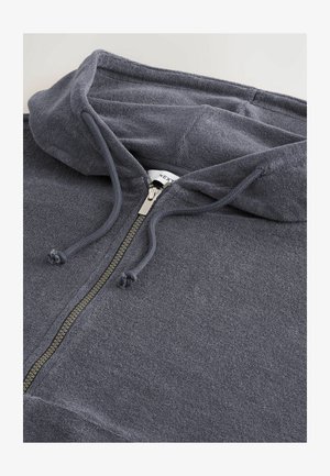 Donkergrijze hoodie met rits, gemaakt van zachte stof. Bevat een gevoerde capuchon, trekkoorden en een metalen rits met een trekriem. Eenvoudig, textuur ontwerp.