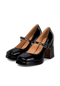 Zapatos Mary Jane de charol negro con punta redonda, tacón cuadrado y una correa decorativa con un pequeño detalle de hebilla.