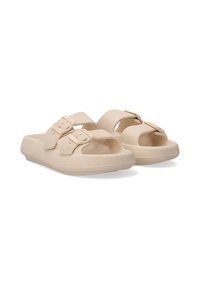Beige slide sandals feature two adjustable straps with buckle closures. Made of textured synthetic material, they have an open-toe design.