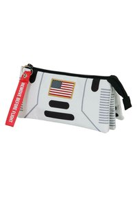 Estuche de lápices diseñado para parecerse a un traje de astronauta, con un exterior blanco, una bandera de EE. UU., detalles en negro y una etiqueta roja de "retirar antes del vuelo".