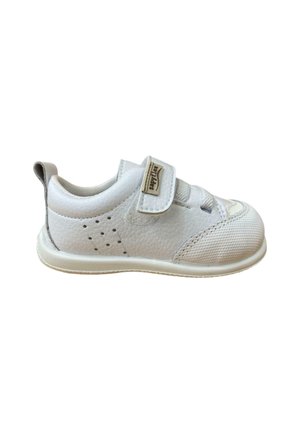 Zapatilla blanca que presenta materiales de cuero y malla, una correa de velcro, lados perforados y una puntera redondeada. Acentos texturizados en la parte superior.
