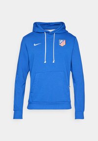 Blaues Hoodie aus Baumwollmischung, mit einer Fronttasche und weißen Kordeln. Nike-Logo auf der oberen linken Seite, Atlético Madrid-Wappen auf der Brust.