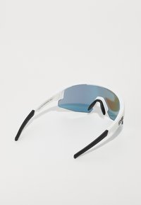 Lunettes de sport blanches avec des verres dégradés bleus, des branches noires et un design profilé enveloppant pour une meilleure visibilité et protection.