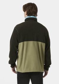 Fleecejacke mit schwarzem oberen Abschnitt und olivgrünem unteren Abschnitt. Mit hellblauem Kragen und Reißverschluss-Seitentaschen.
