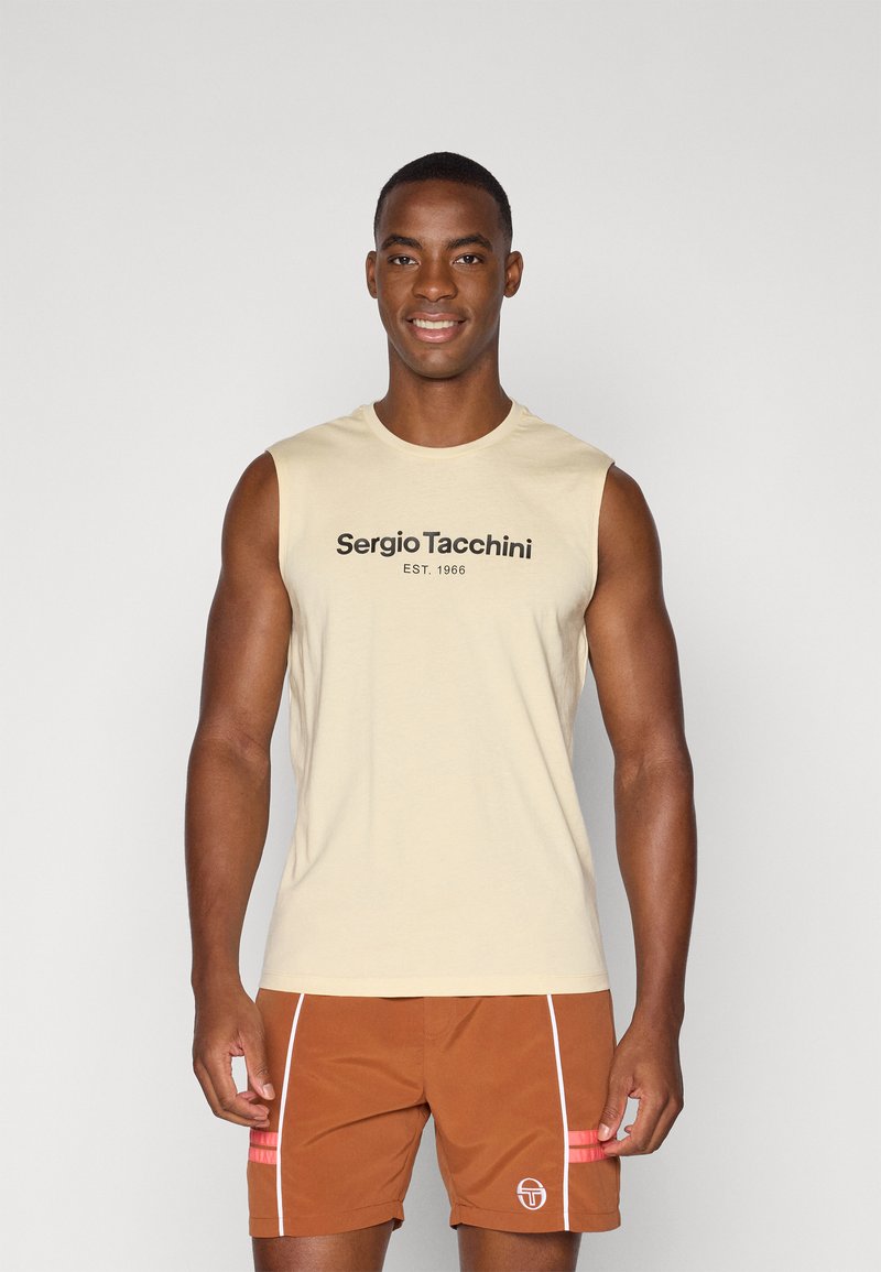 Beige ermeløs skjorte med sort "Sergio Tacchini EST. 1966" tekst; kombinert med brune shorts med hvite detaljer og en logo.