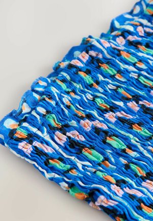 Tissu bleu à motifs présentant une texture froncée avec des designs multicolores d'orange, de vert et de formes pastel. Matière douce et extensible.