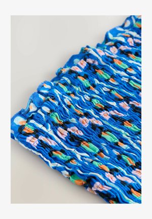 Tissu bleu à motifs présentant une texture froncée avec des designs multicolores d'orange, de vert et de formes pastel. Matière douce et extensible.