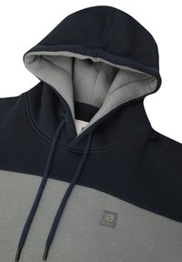 Huppari, jossa harmaa vartalo ja tummansinisiä yksityiskohtia. Valmistettu pehmeästä kankaasta, sisältää narut ja logopatchin.