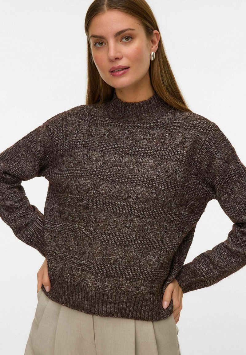 Maglione marrone lavorato a maglia con collo alto, caratterizzato da un motivo testurizzato e polsini e orlo a coste. Realizzato in un materiale morbido e caldo.