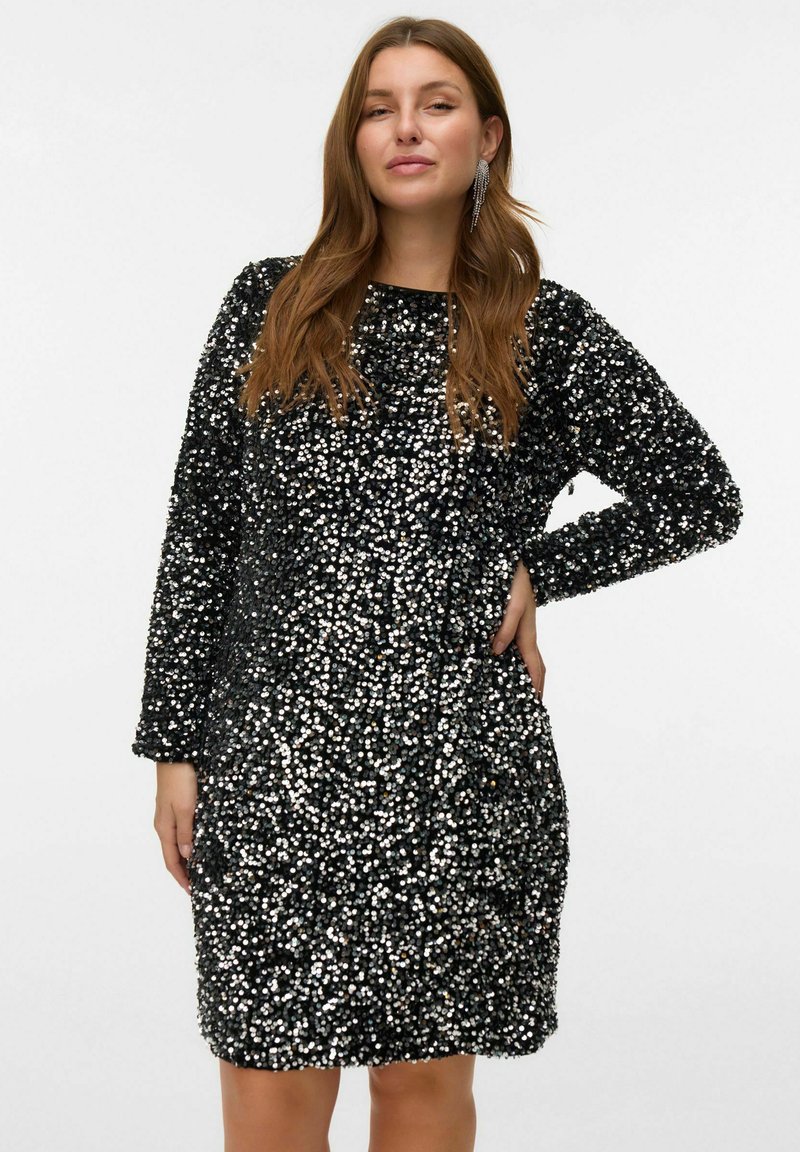 Vestido negro cubierto de lentejuelas redondas, de mangas largas, con altura por encima de la rodilla, escote redondo, superficie texturizada, brilla a la luz.