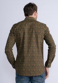 Langslalig overhemd met een groene basis en een herhalend geometrisch patroon in oranje en bruin. Glad stof, met knoopmanchet, klassieke kraag.